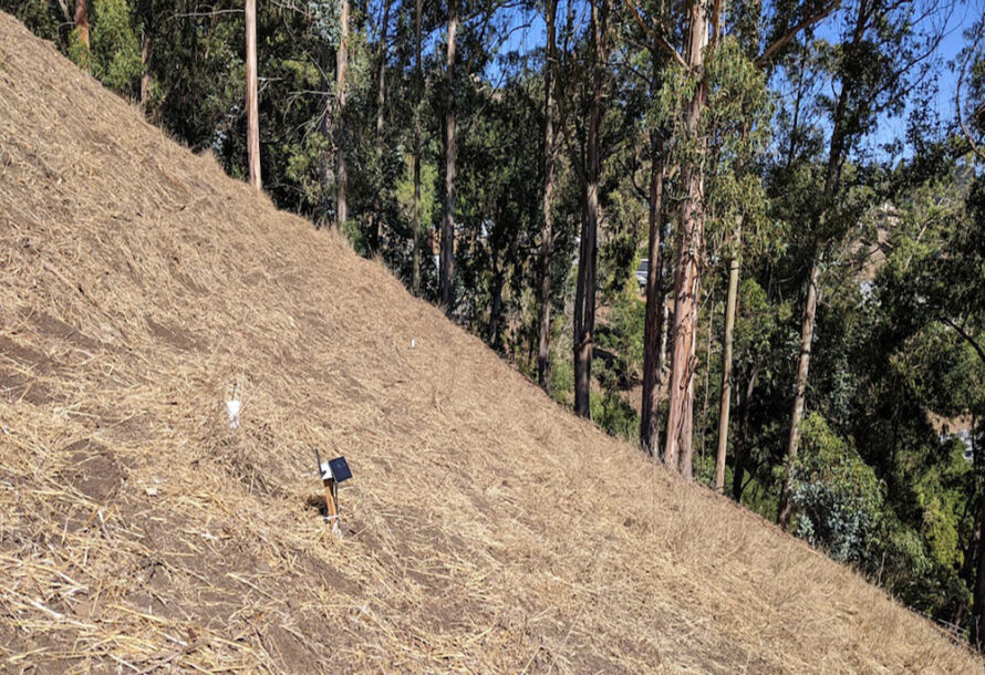A small remote-sensing device on a brown hillside