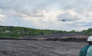 drone flies over field of ash